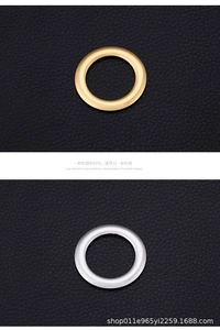 Detailed view of polished gold and silver metal ring charms on textured black leather
