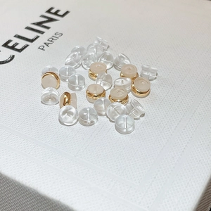 Macro detail of transparent silicone and gold metal earring backs for stud security