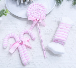 Close-up of pink and white striped velvet candy ornaments with bows for Christmas decor