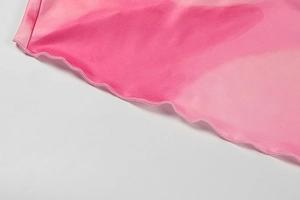 Detail of pink garment with lettuce edge hem showing fine stitching and satin sheen
