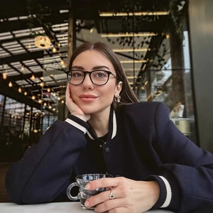 Occhiali da vista scuri montatura intera su modella in un caffè, design classico opaco