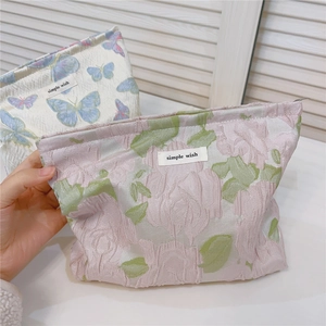 Detailed macro view of butterfly jacquard fabric and simple wish woven label on the pouch