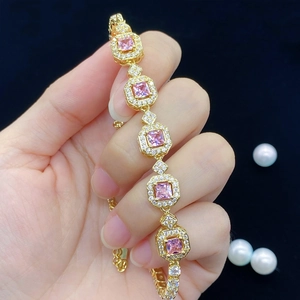 Detail von rosa quadratischen Steinen an einem vergoldeten Armband mit Zirkonia-Besatz