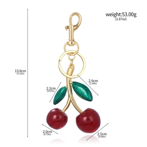 Detailed view of red glitter cherry keychain with gold clasp showing 13cm length