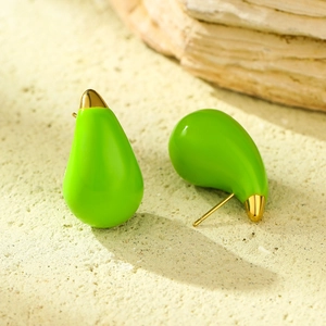 Detailed close-up of vibrant green teardrop earrings with gold plating on textured stone