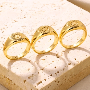 Three-piece 18K gold plated S925 silver sunburst smile rings on travertine stone