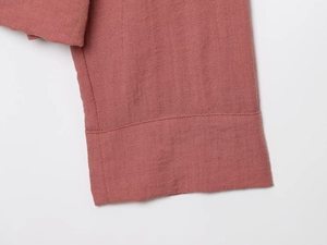 Detail of linen jacket cuff showing fabric texture and neat stitching in dusty pink