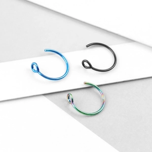 Close-up of stainless steel nose rings in blue, black, and rainbow electroplated finish