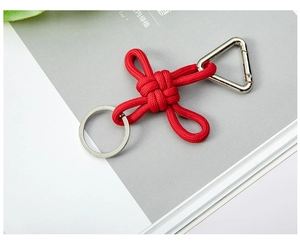 Macro shot of red hand-woven paracord keychain with silver metal clip on magazine