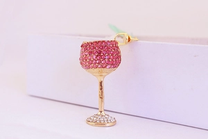 Detail of creative wine glass earring with pink rhinestones and gold metal base