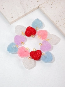 Close-up of candy-colored heart charms with sugar texture and golden metal loops