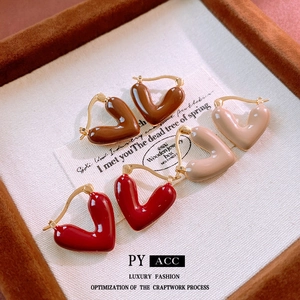 Vintage heart hoop earrings in red brown and beige colors on a jewelry tray