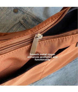 Close-up of premium silver metal zipper and brown nylon fabric on a casual tote bag