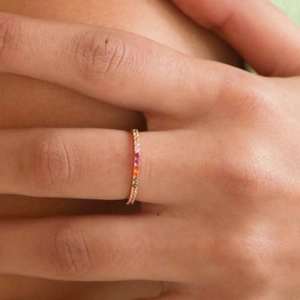 Rainbow gemstone eternity ring in 18k gold plating shown on model finger