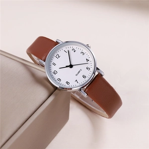 Minimalist quartz watch with brown PU leather strap and silver dial on display case
