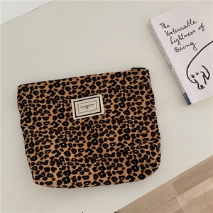 Close-up of leopard print canvas makeup bag with zipper and Pleasant Time logo