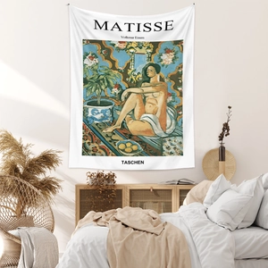 Artistic Matisse tapestry hanging on a minimalist bedroom wall above a cozy bed