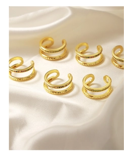 Detailed macro view of gold double-layer ear clips with colorful stones on silk