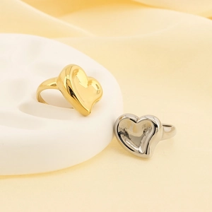 Close-up of gold and silver heart-shaped stainless steel rings on a velvet surface
