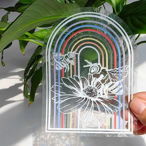 Close-up of rainbow suncatcher sticker with bee and flower art reflecting light