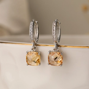 Detail of square champagne gemstone earrings with sparkling cubic zirconia pavé