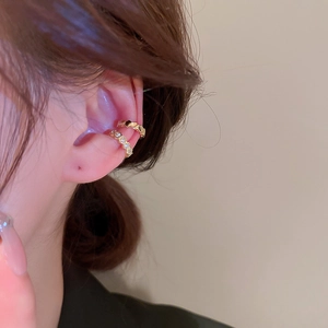 Minimalist gold-plated C-shaped ear cuffs with zircon crystals shown on a model's ear