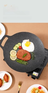 Close-up of non-stick stone coating grill pan cooking steak and eggs on camping stove