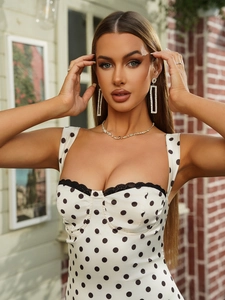 Détail de la robe blanche à pois avec une élégante bordure en dentelle noire au décolleté