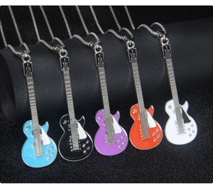Close-up of five colorful guitar pendant necklaces with enamel finish on black leather background