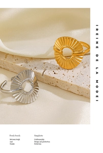 Detailed view of gold and silver textured round open rings on travertine stone