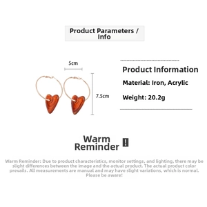 Detail view of large gold hoop earrings with amber acrylic heart and size dimensions