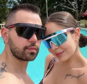 Close-up of oversized wraparound sunglasses with red stripe logo detail on the temple