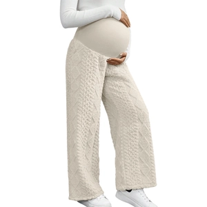Detail of high-waisted maternity pants showing thick cable knit texture in beige