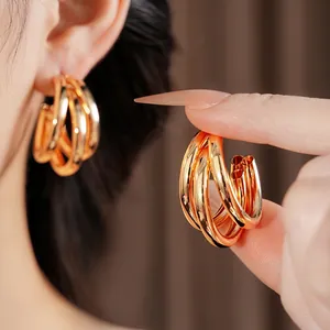 Modern minimalist multi-layer gold C-shaped hoop earrings with a layered metal ring design