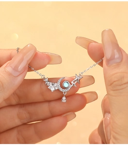 Gros plan sur le collier croissant de lune en argent avec pendentif pierre de lune et étoiles