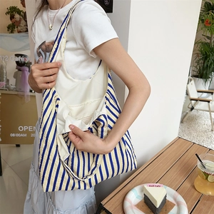 Detailed view of striped canvas tote bag interior with white lining and inner pocket