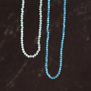 Close-up of colorful beaded necklaces with blue amazonite stones and gold accents