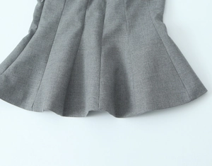 Détail des plis et des coutures fines sur un haut bustier gris à basque évasée