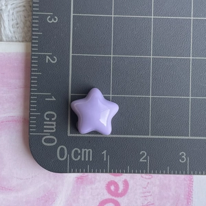Macro view of a 1.5cm purple star resin accessory measured on a metric scale ruler