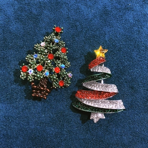 Festive Christmas tree brooches with colorful rhinestones on a blue velvet background