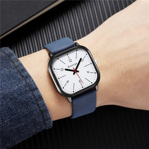 Close-up of square dial watch with textured face and blue leather strap on wrist