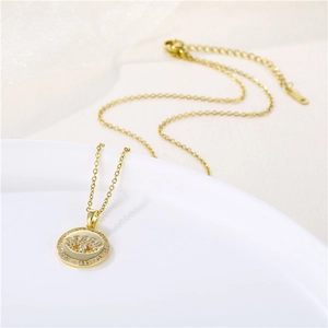 Collier œil maléfique doré avec pendentif en zircone cubique sur un plat en céramique