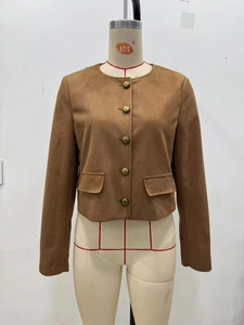 Close-up of tan suede jacket with vintage bronze buttons and two front flap pockets