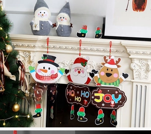 Christmas snowman and reindeer paper hanging ornaments with festive banners on a mantelpiece