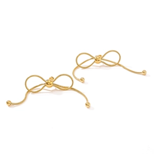 Elegant gold bow earrings with long snake chain tassels on a clean white background