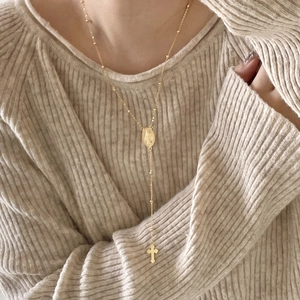 Golden 925 silver Y-shaped rosary necklace with Maria medal and cross on knit sweater