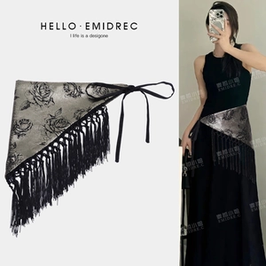 Detail of grey rose pattern fabric belt with long black tassels and tie closure