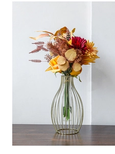 Detailed close-up of a gold metal lantern vase with a vibrant autumn silk flower bouquet