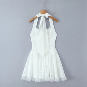 Détail d'une robe dos nu blanche avec broderie anglaise et ourlet à volants