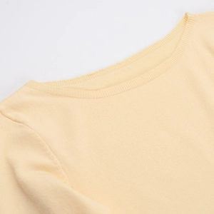 Primer plano del escote ondulado y la textura de punto en el vestido amarillo pálido